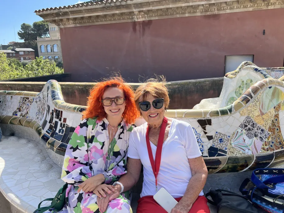 Liliia with a client on the mosaic bench at Park Güell